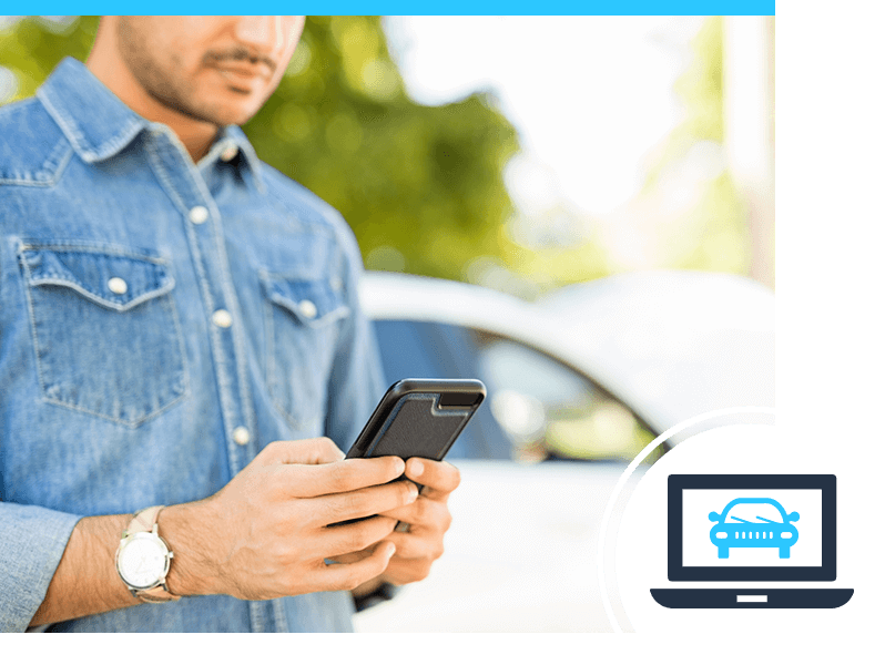 A person looking down on his phone while in a car dealership parking lot